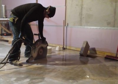 man sawing concrete floor